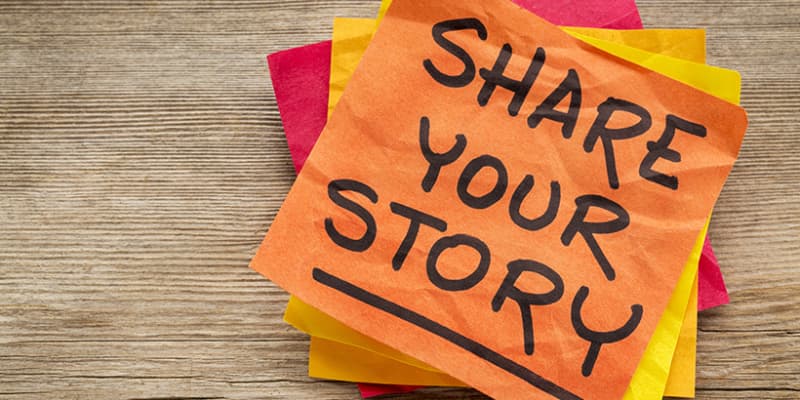 "Share Your Story" is written on an orange Post-it Note.