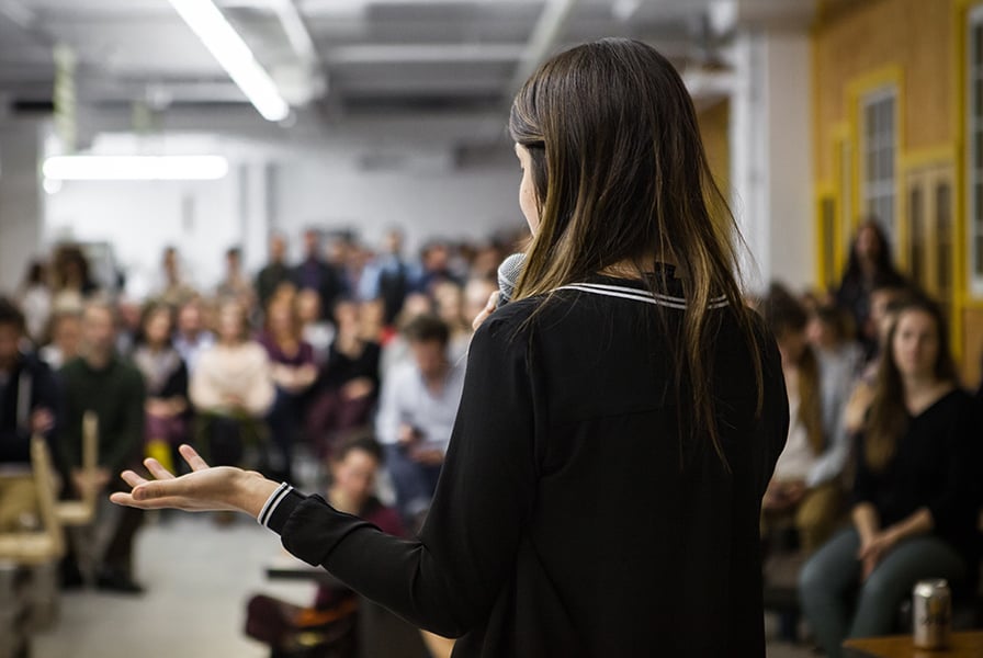 A woman speaks in front of a crowd