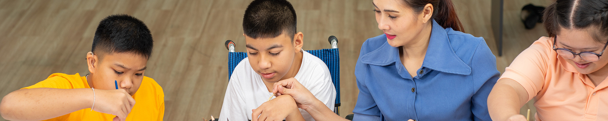 Students with disabilities take part in an art class with a teacher.